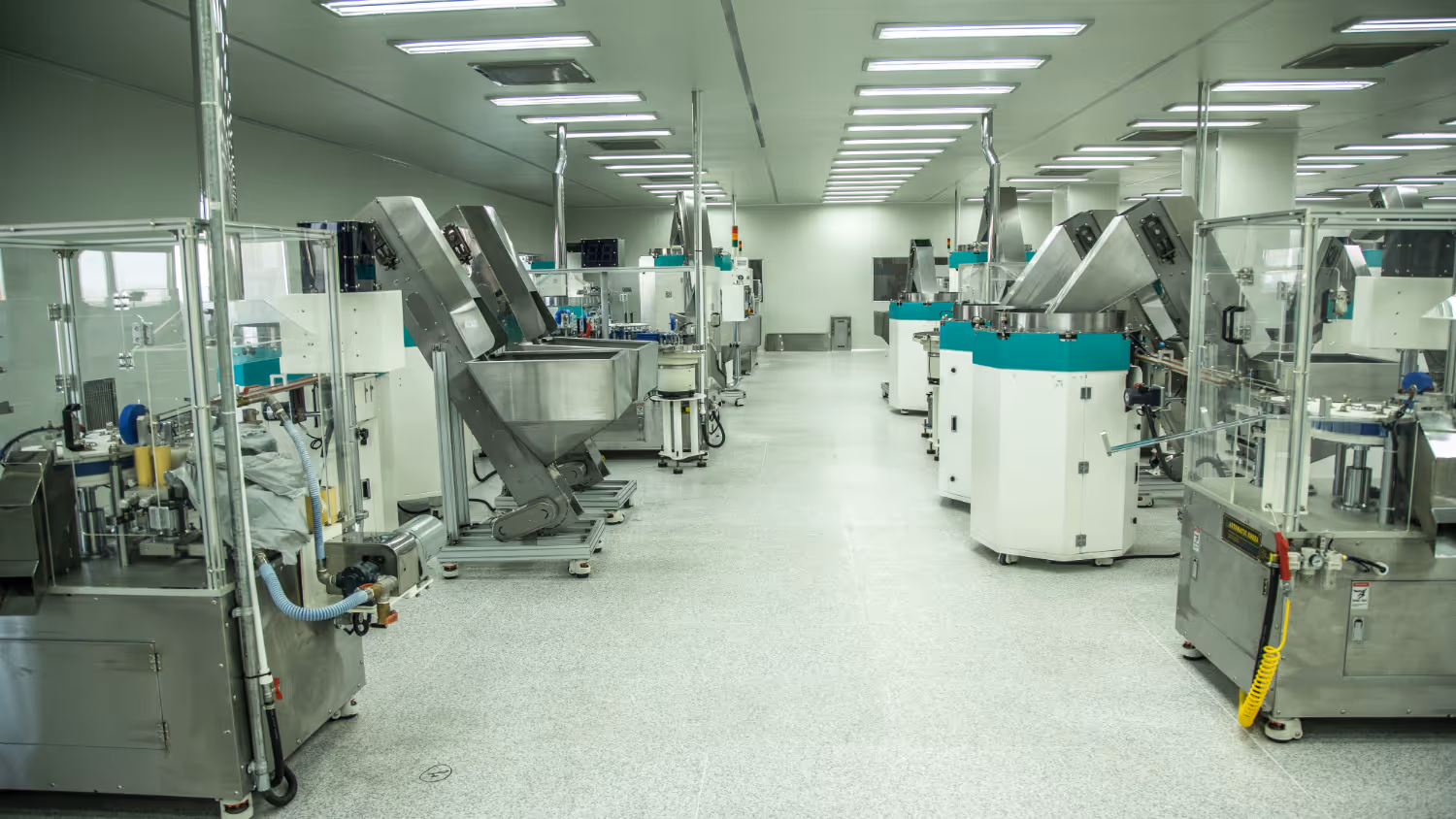 Clean, well-lit manufacturing facility with rows of industrial machines and equipment for automated production.